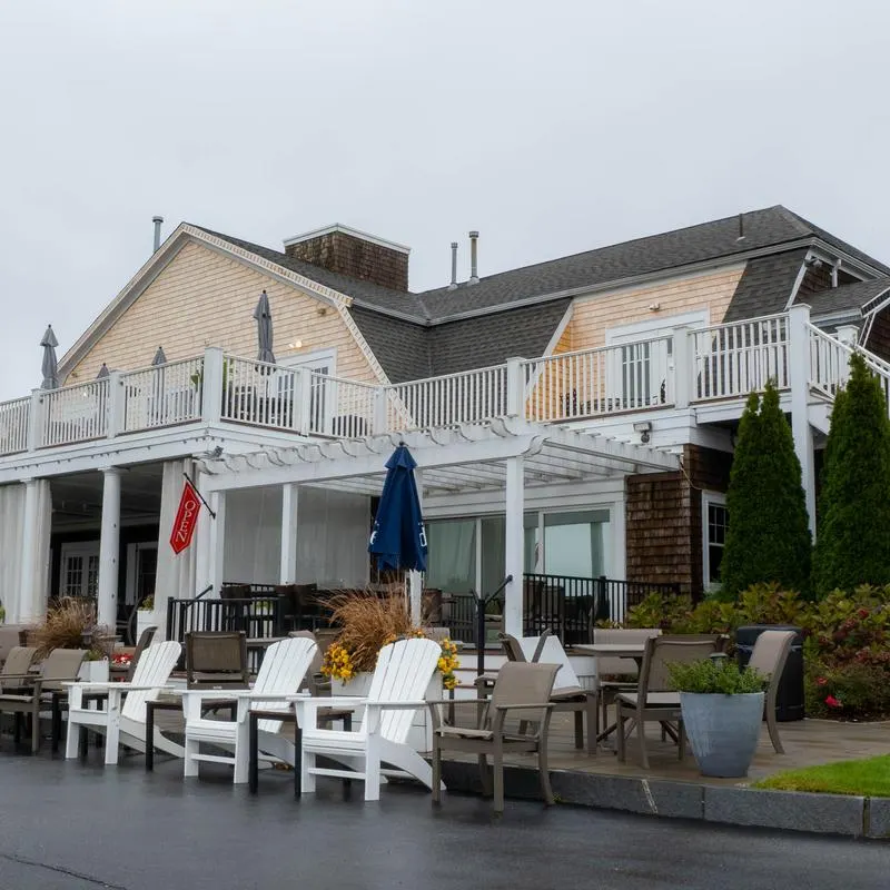 The Brookside clubhouse with deck seating and white Adirondack chairs.