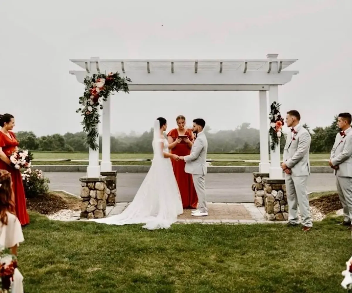 A wedding ceremony under a floral pergola at The Vue at Brookside.