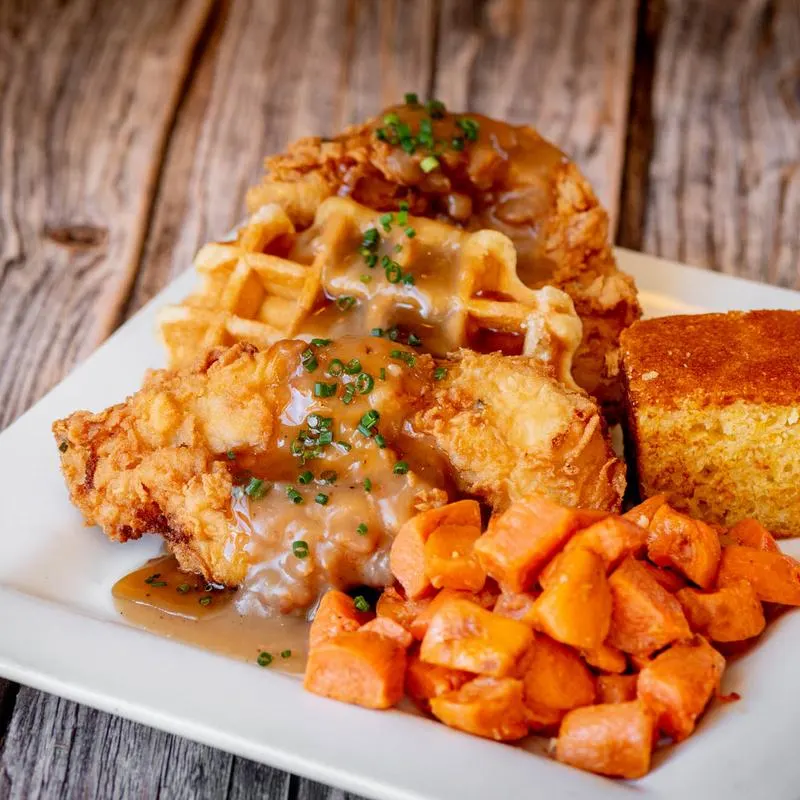 Fried chicken and waffles with sweet potato hash and cornbread.